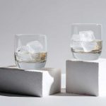 Gläser Wasser auf Steinen als Symbol für tägliche Trinkmenge
