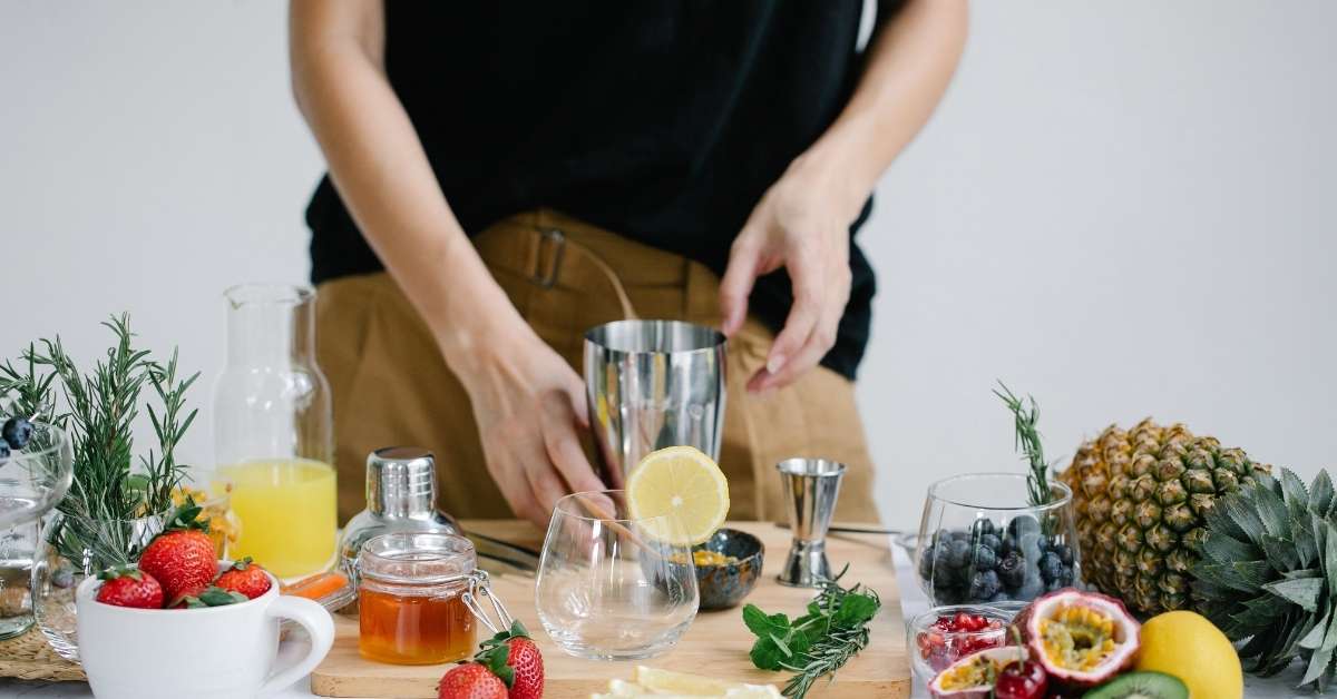 Zutaten und Flaschen bei der Zubereitung eines alkoholfreien Cocktails